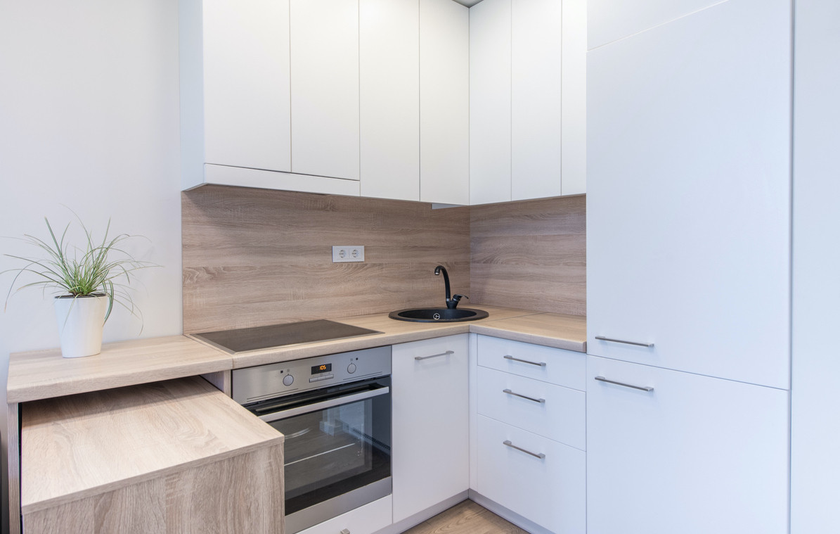 neliela stūra virtuve ar baltām fasādēm